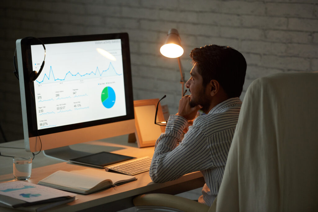 Pensive businessman looking at a financial report on a computer screen