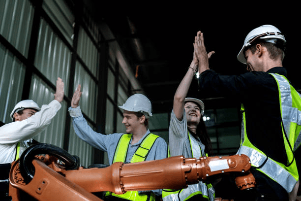 Human and robot arm high-fiving in factory